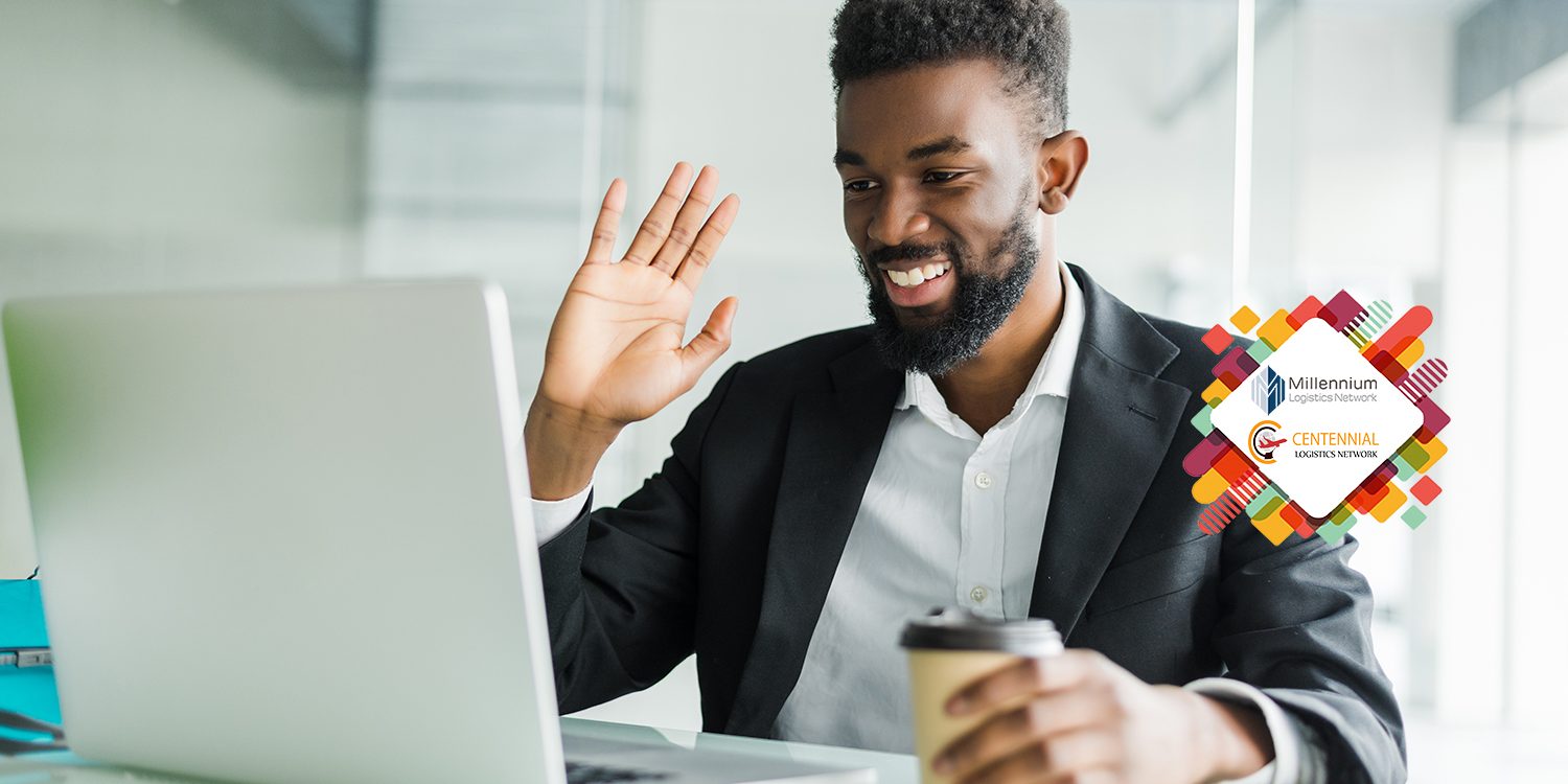 Young African manager with stubble sitting in front of open laptop wearing earphones while having video conference call with business partners